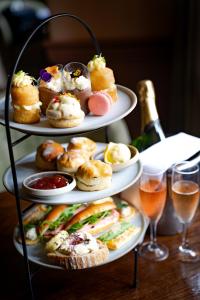 a three tiered tray of pastries and sandwiches and glasses of wine at Charingworth Manor in Chipping Campden