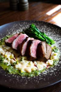 a plate of food with meat and broccoli on a table at Charingworth Manor in Chipping Campden