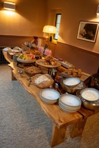 a long wooden table topped with plates of food at Charingworth Manor in Chipping Campden
