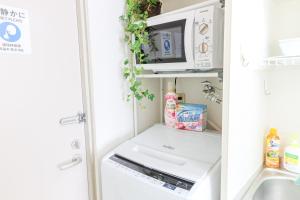 an open refrigerator with a microwave and a sink at ハイクレスト中野203 in Tokyo