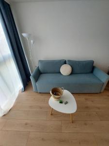 a living room with a blue couch and a table at Sky Hills 2 Apartment in Sandanski +11 photos