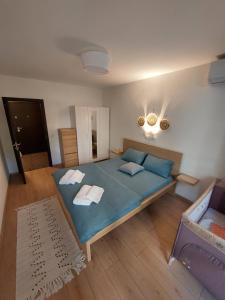 a bedroom with a blue bed with towels on it at Sky Hills 2 Apartment in Sandanski