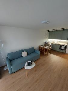 a living room with a blue couch and a table at Sky Hills 2 Apartment in Sandanski