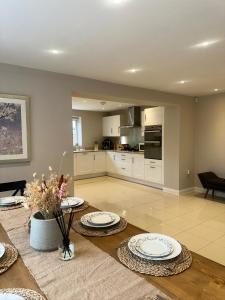 una sala de estar con una mesa con platos. en Luxury 6-Bedroom House 5 minutes from Bicester Village Shopping Outlet, en Chesterton