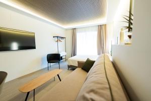 ein Hotelzimmer mit einer Couch und einem Bett in der Unterkunft Edificio Reyes Católicos Alicante Centro by Renthas in Alicante