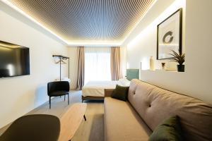 ein Wohnzimmer mit einer Couch und einem Bett in der Unterkunft Edificio Reyes Católicos Alicante Centro by Renthas in Alicante