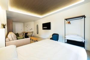 ein Hotelzimmer mit einem Bett und einem Wohnzimmer in der Unterkunft Edificio Reyes Católicos Alicante Centro by Renthas in Alicante + 59 Fotos