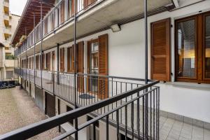 Un balcón de un edificio con puertas y ventanas de madera. en Maison Le Chic, en Bérgamo