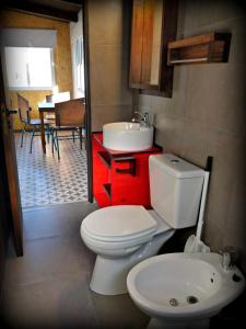 a bathroom with a toilet and a sink and a table at CASA FARO ARTE in Potrerillos +71 photos