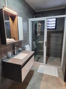 a bathroom with a shower and a sink and a mirror at Miami Suites Tamatave in Toamasina +45 photos