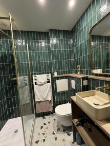 ボルドーにあるAppartement 1 Chambre au Cœur de Bordeauxの緑のタイル張りのバスルーム(トイレ、シンク付) +26枚の写真