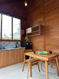 a kitchen with wooden walls and a wooden table and chairs at Villa Pondok Utu, Ubud - Bali in Ubud