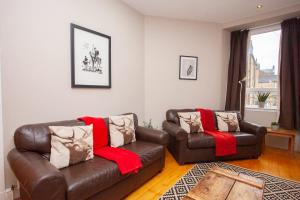 una sala de estar con un sofá y una silla en Beautiful 2 Bed Apartment Rose St, en Glasgow