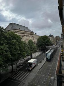 ボルドーにあるAppartement 1 Chambre au Cœur de Bordeauxの建物前のバス停付き街道