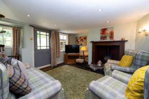 a living room with two couches and a fireplace at Clematis Cottage Tealby LN8 3XU in Tealby