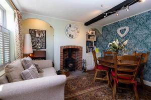 a living room with a table and a fireplace at Clematis Cottage Tealby LN8 3XU in Tealby