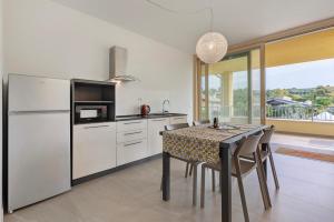 una cocina con una mesa y un refrigerador en Agriturismo Le Campagnole Red, en Bardolino