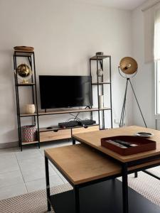 a living room with a tv and a table at Appart premium à 5 min de l aeroport Orly in Athis-Mons +42 photos
