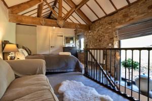 a living room with a couch and a stone wall at Finest Retreats - End Barn at Blackclough Farm in Buxton