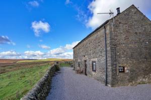 an old stone building with a cross on top of it at Finest Retreats - End Barn at Blackclough Farm in Buxton