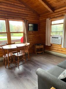 a dining room with a table and chairs in a cabin at Adventures East Cottages and Campground in Baddeck Inlet
