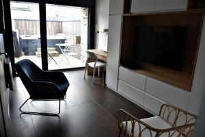 a living room with a chair and a television at La Maison du Quai Triplex de charme 4 étoiles en hyper centre avec SPA in Landerneau