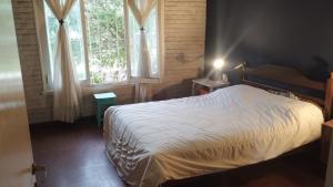 - une chambre avec un lit blanc et 2 fenêtres dans l'établissement Casa Cedrón, à Mar del Plata