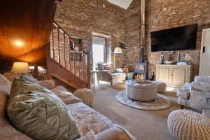 a living room with a couch and a tv at Finest Retreats - Middle Barn at Blackclough Farm in Buxton