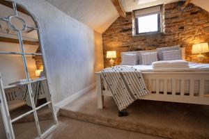 a bedroom with a bed in a stone wall at Finest Retreats - Middle Barn at Blackclough Farm in Buxton