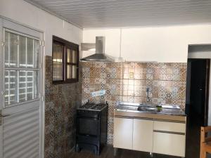 eine kleine Küche mit Herd und Spüle in der Unterkunft Chuy Aparts 1 in Chuy + 5 Fotos