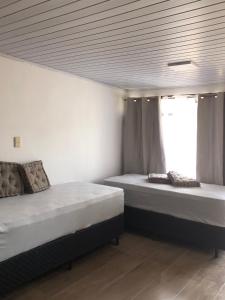 ein Schlafzimmer mit zwei Betten und einem Fenster in der Unterkunft Chuy Aparts 1 in Chuy