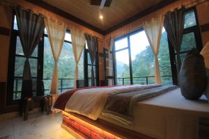 本贾尔Sukoon Resort的一间卧室设有床铺和享有山景的大窗户