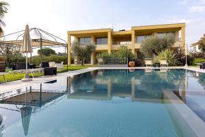 a swimming pool in front of a building at Agriturismo Le Campagnole Green in Bardolino