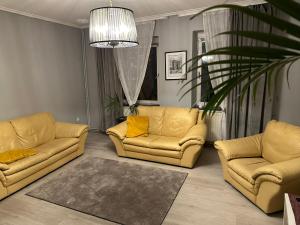 un soggiorno con due divani gialli e una pianta di Ferienwohnung Dreiländerblick a Perl