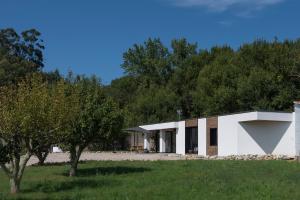 ein modernes Haus mit weißer Fassade in der Unterkunft O REMANSO do CORGO in Oleiros