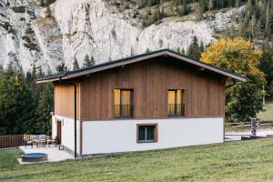 a house in front of a mountain at Grand Chalet Lacu Rosu in Lacu Rosu