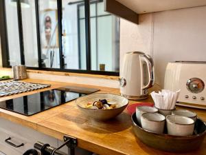 un bancone della cucina con ciotole su un piano di lavoro in legno di Le Prestige des Papes-Élégance Confort Cœur d'Avignon ad Avignone Altre 23 foto