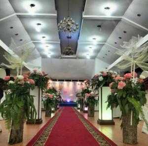 a hall with a red carpet and pink flowers at Sai Gon Can Gio Resort in Cần Giờ +62 photos