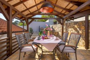 a patio with a table and chairs under a wooden ceiling at SROK luxury apartment with pool in Kastav