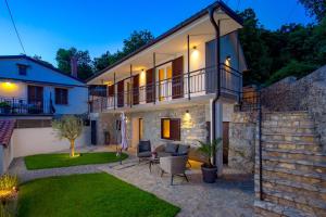 a villa with a patio and a house at SROK luxury apartment with pool in Kastav