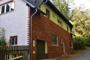 una casa in mattoni con una porta verde e una recinzione di Flynnhouse a Aš