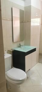 a bathroom with a toilet and a sink and a mirror at Sunset Plateau in Praia