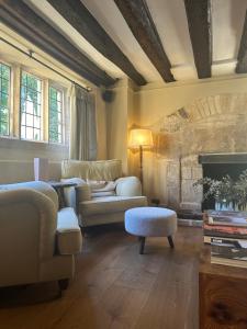 a living room with a couch and a fireplace at Charingworth Manor in Chipping Campden