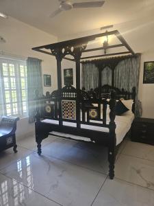 a bedroom with a canopy bed in a room at Padikkal Bungalow in Vayittiri