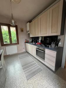 a kitchen with wooden cabinets and a stove top oven at Comfortable apartment in Castell'Arquato of 80 m² in CastellʼArquato