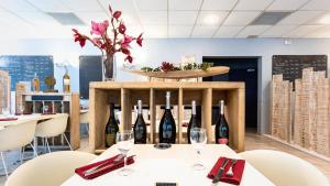 a restaurant with wine bottles on a table at Au P'tit Creux des Landes in Ychoux