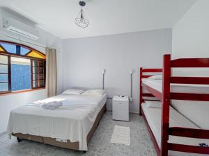 a bedroom with two bunk beds and a window at Pousada Yurgs in Caraguatatuba