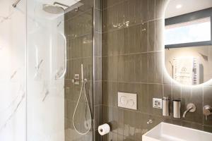 a bathroom with a shower and a sink and a mirror at VISIONAPARTMENTS Lugano - contactless check-in in Lugano +32 photos