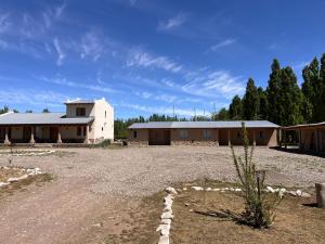 a large building with a dirt road in front of it at Finca Los Arrieros - Malargüe in Malargüe