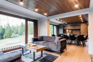 a living room with a couch and a table at Grand Chalet Lacu Rosu in Lacu Rosu